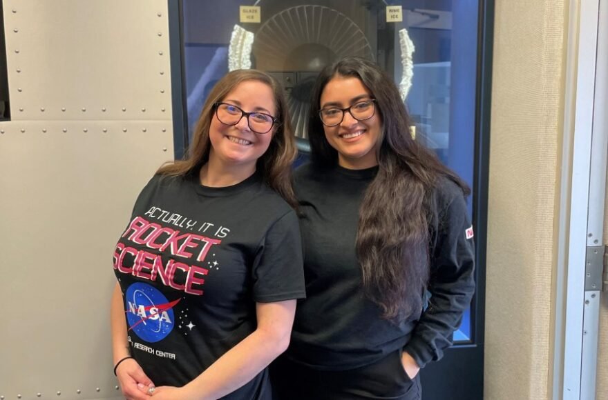 Kim Alexander และ Ashley Rodriguez ยืนถ่ายภาพที่ศูนย์วิจัย Glenn ของ NASA